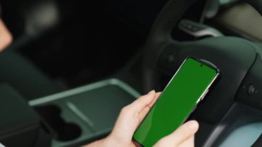 Çevre dostu araba konseptiyle tatil gezisi. EV batarya durumu için boş telif alanı yeşil ekran arabaları tutan sürücü koltuğundaki çevre bilinci olan genç çift. Yükselt