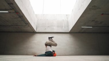 Modaya uygun mutlu hipster break dans ya da serbest dans yapıyor. Profesyonel break dansçı B-boy dansı yaparken şık kıyafetler giyiyor. Modern yaşam tarzı. Açık hava sporu 2024. Yumuşak bir şekilde..