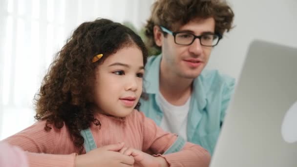 美国女孩一边看着笔记本电脑屏幕 一边把铅笔插在耳朵上 快乐的高加索父亲指着计算机解释编码工程提示和人工智能生成可爱的女儿 教育学 — 图库视频影像