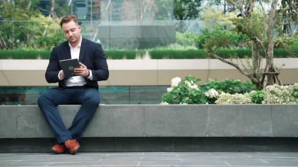 Empresário Profissional Sentado Parque Enquanto Trabalhava Tablet Lendo Relatório Equipe — Vídeo de Stock