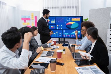 Pazarlama stratejisi için modern toplantıda veri analizi paneli ekranında sunan bir işadamı. Bir grup iş adamıyla konferans odasında iş sunumu. Uyum