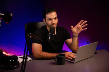 Yayıncı, fanclub dinleyicisiyle mikrofon kullanarak konuşuyor. Mor neon ışıklı modern stüdyoda yaratıcı olumlu düşünce konseptiyle canlı yayında finansal sorunları tartışıyor. Tahmin et..