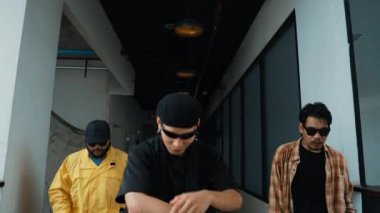 Modern koridor alışveriş merkezinde çok kültürlü hipster grubu yürüyüp sokak dansı yapıyor. Profesyonel aktif sokak dansçısı hip-hop müziğine adım atıyor. Açık hava sporu 2024 hiphop..