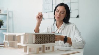 Profesyonel mühendis mimarın üçgen ölçekli ölçü evi modelini kullanarak modern ofisteki yapı uzunluğunu not alarak yakınlaşması. İş tasarımı. Tertemiz..