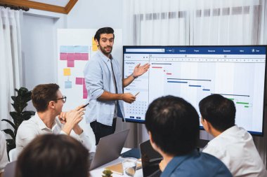 Proje yöneticisi monitörde proje yönetimi yazılım görüntülemesi, proje görevinin ilerlemesini izlemek ve toplantı masasında program planı yapmak suretiyle ekiple iletişim kurar ve işbirliği yapar. Tedbirli