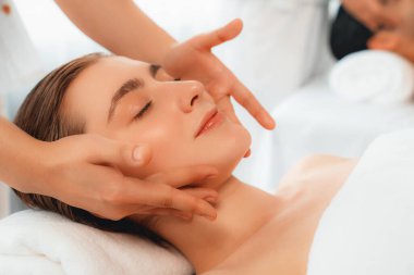 Kafkasyalı çift stres önleyici kafa masajının keyfini çıkarıyor ve lüks otellerde ya da otel spa salonlarında gündüz kaplıcalarında yüz güzelliği eğlencelerini şımartıyor. Sessiz.