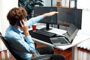 Başarılı genç yatırımcı, akıllı telefondan iş ortağına Dinamik Finansal Değişim Yatırım Dizüstü bilgisayarı ile modern ofisteki mevcut pazar grafiğinde gerçek zamanlı arıyor. Toplayıcı.