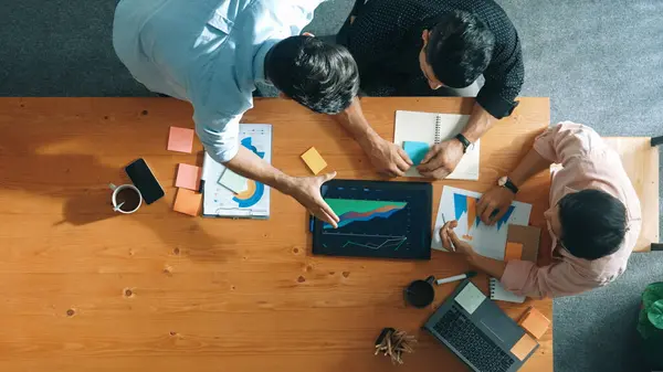 エグゼクティブ マネージャーは会議室の同僚に財務グラフを説明する 多様なマーケティングチームがタブレットでテーブルに座っている間 アイデアと計画戦略を共有するという空想的なビュー コンベンション — ストック写真