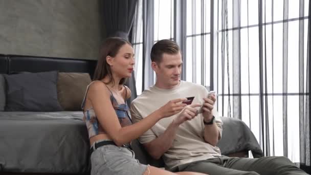 커플은 카드로 지불하기 스마트 온라인 디지털 지갑을 사용하여 침실에 모바일 — 비디오