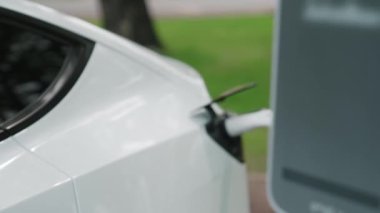 EV elektrikli araç EV şarj istasyonu ulusal park veya açık hava orman manzaralı. Çevre dostu EV arabalarla yaz ormanlarında doğal koruma. Yükselt