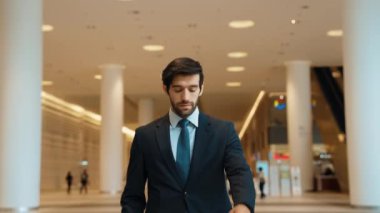Kafkasyalı zeki iş adamı iş arkadaşını beklerken saate bakıyor. Bulanık geçmişiyle alışveriş merkezinde dikilirken yönetici takım elbise giyiyor. Yatırımcı mavi takım elbise giyer. Sevinçli..