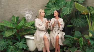 Modern otelde küveti olan tropikal ve egzotik bir spa bahçesi ya da bornozlu iki genç kadınla kahve içip, yemyeşil yeşilliklerle çevrili boş ve sağlıklı yaşam tarzının tadını çıkarmak. Blithe