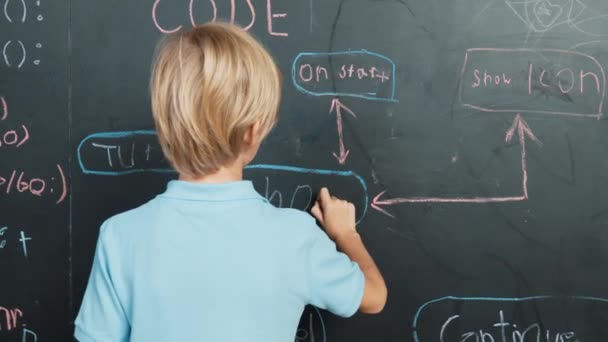 聪明男孩在黑板上写工程技术提示的背景图 同时转身并展示一个大拇指 利用Stem课题库中的编码和编程系统 对项目进行规划 Erudition — 图库视频影像