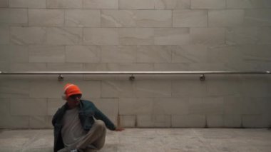 Asyalı akıllı hipster, kulaklık ve şık kıyafetler giyip hip hop şarkıları dinlerken gri arka planlı enerjik break dans gösterisi yapıyor. Açık hava sporu 2024. Hip hop hareketi. Yumuşak bir şekilde..