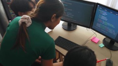 Yavaş çekim arkası yazılım geliştirici mühendisi bilgisayar programlama için birlikte çalışarak hata ayıklama kodunu çözüyor, ofiste monitörde karmaşık algoritmaları çözüyor. Filizlenen