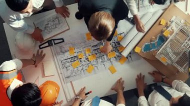 Proje planına bakarken mühendis ekibinin el sıkışması. Birlikte çalışan ve mühendislik inşaatı için plan yapan bir grup akıllı iç mimar. Hizalama.