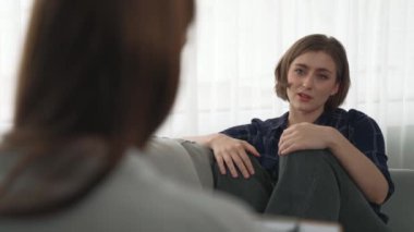 Psikologla ruh sağlığı terapisi gören üzgün travma sonrası stres bozukluğu olan bir kadın. Yaşam sonrası depresyon veya keder. Hayal kırıklığına uğramış genç bir kadın klinikteki duygular hakkında prim psikoloğuyla konuşuyor.