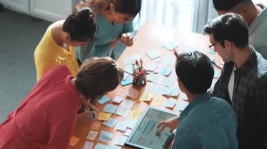 Mobil telefon arayüzü ile ilgili yetenekli programcı beyin fırtınası fikrinin üst görüntüsü kablo prototipi kullanarak uygulama geliştirme aşamasında. Yapışkan notlarla birlikte web tasarımcısı planlama yapıyor. Sempozyum.