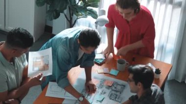 İnşaat inşaatı sırasında akıllı inşaat mühendisi proje planının en üst görünümü. Mimarla iç mimar birlikte çalışırken dizüstü bilgisayar kullanarak planı kontrol ediyorlar. Sempozyum.