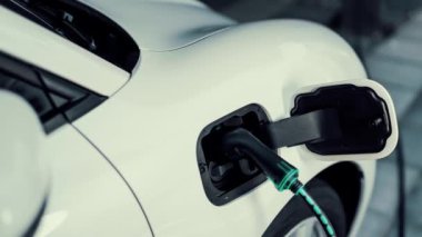 Şarj istasyonundan çevre dostu araba şarj oluyor. Fütürist hologram görüntü bataryası durumu. Alternatif enerji teknolojisinde son gelişmeler ve şarj edilebilir EV araba. İnceleyin