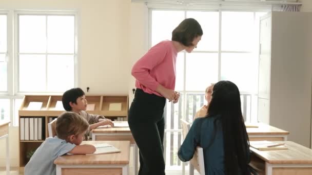 Kaukasiska Lärare Promenader Och Kontrollera Eleven Läxor Klassrummet Medan Olika — Stockvideo