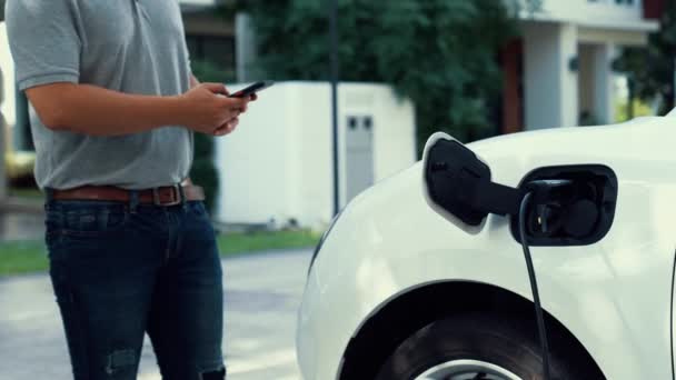 Moderne Lifestylemenschen Führen Elektroauto Ladegerät Der Heimischen Ladestation Ein Und — Stockvideo