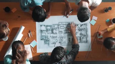 Beyin fırtınası yapmak için yapışkan notlar kullanarak inşaat mühendisi yazma ve planlamasının en üst görüntüsü. Yukarıdan aşağıya iş adamlarının proje planları ve ekipmanlarla masaya not almalarını gösteren bir görüntü. Sempozyum.