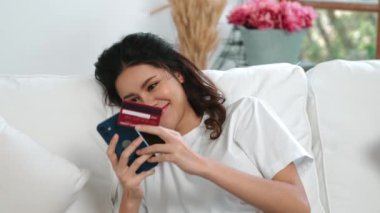 Kadın alışverişi ya da internet pazarında online ödeme modern yaşam tarzı için satılık eşyalar arıyor ve canlı siber güvenlik yazılımı tarafından korunan cüzdandan çevrimiçi ödeme için kredi kartı kullanıyor