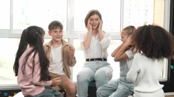 Smart Kaukasiska Lärare Undervisning Medan Sitter Golvet Tillsammans Omgiven Olika — Stockvideo