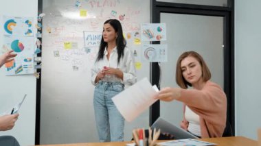 Profesyonel kadın lider, beyin fırtınası zihin haritası kullanarak yaratıcı pazarlama planını sunarken, iş arkadaşı da modern iş toplantı odasındaki uzman yatırımcılara toplantı belgelerini veriyor. Tertemiz..