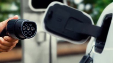 Kameranın önüne odaklanmış EV şarj cihazı fütüristik akıllı dijital EV batarya durum hologramını gösteriyor. EV araba şarjı sürdürülebilir güç için alternatif enerji kullanıyor. İnceleyin
