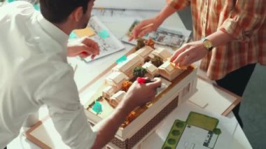Akıllı mimar ya da inşaat mühendisi bina yapısı fikrini not edip plana yapıştırıyor. Yöneticinin çeşitli meslektaşları ve ev planlarıyla birlikte çalıştığı hava görüşü. Hizalama.