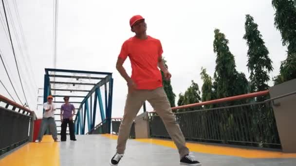 熟練したヒップスターは 低角度のカメラで橋で足を踏みます ブレイクダンサー練習Bボーイパフォーマンスやフリースタイルダンス カメラでポーズ 現代のライフスタイル アウトドアスポーツ 2024 スプライトリー — ストック動画