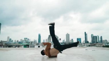 B-boy dans gösterisi çatıda sokak dansçısı ve gökyüzü dövüşçüsü, şehir manzaralı. Çekici Asyalı hipster enerjik adımlar atıyor. Break dansçı sokak dansı. Açık hava sporu 2024 hiphop..