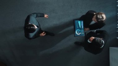 Profesyonel iş adamının yukarıdan görünüşü bir ekibe katıldı ve yönetici müdürle tokalaştı. Akıllı pazarlama ekibi tabletteki yatırım verilerini analiz etmek için birlikte çalışıyor. Müdürlük.