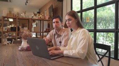 Baharda Cafe Garden 'da dizüstü bilgisayarda çalışan genç bir çift kahve dükkanındaki dinginlik ortamının tadını çıkarıyor. Uzaktan çalışan ya da blog yazan dijital göçebe ya da üniversite öğrencisi. Yararlı