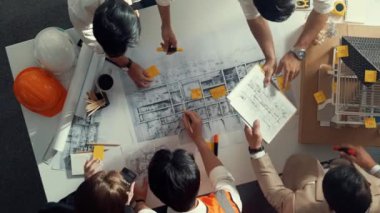 Becerikli mühendis ekibinin ev inşaatından bahsedişinin en alt görüntüsü. Mimar ya da tasarımcı grubunun planlar hakkında beyin fırtınası yapmak için tartışan ve yazan hava görüşü. Hizalama.