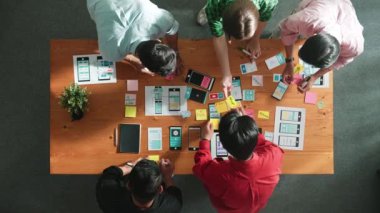 Mobil telefon arayüzü için Ux Ui tasarımı planlarken iş adamlarının yapışkan notlar üzerine yazı yazma fikrine tepeden aşağı bakış açısı. Bir grup yaratıcı tasarımcı kablo prototip tasarımı üzerinde çalışıyor. Cemaat.