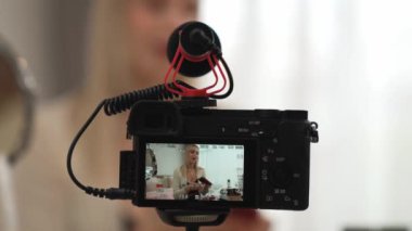 Güzellik ve kozmetik öğretim videosu içeriği yapan kamera görüntüsü kadını ya da perde arkası görüntüsü. Güzellik blogcusu izleyicilere ya da sosyal medya takipçilerine güzellik hizmetinin nasıl uygulanacağını gösteriyor. Blithe