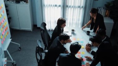 İş adamlarının toplantı odasında pazarlama stratejisi planlarken yapışkan notlar kullanarak beyin fırtınası yapma fikrine en iyi bakış açısı. Çeşitli takımlar mali planı tartışıyor. Takım çalışması konsepti. Müdürlük.