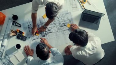 Mühendis ekibiyle tasarım planlarken iç mimar yazımının yukarıdan aşağı görüntüsü yapışkan notta. Çeşitli mimarlar ve usta yöneticilerden oluşan bir grup bina inşaatı arıyor. Hizalama.