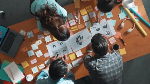 商业团队的顶视图在会议桌上写上图形标识 并附有彩色粘贴笔记和设计 同时解释想法 项目经理与聪明的团队分享想法 解释概念艺术 专题讨论会 — 图库视频影像