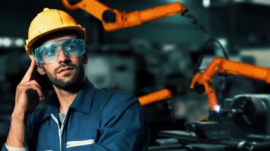 XAI Mühendisi, fabrikadaki robot kolu kontrol etmek için siber robot yazılım kullanıyor. IOT yazılımı kullanarak internet ağına bağlı uzmanlar tarafından kontrol edilen otomasyon üretim süreci.