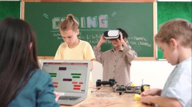 VR kulaklık takan enerjik bir çocuk sınıfta sanal dünyaya giriyor. Öğrenci programlama sistemi, çocuk elektronik panoyu tamir ederken yapay zeka ile mühendislik komut yazılımı oluşturdu. Pedagoji.