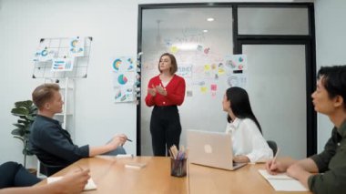 Genç liderin kapanışı, proje hakkında beyin fırtınası yapan meslektaşı ve proje yöneticisi tarafından çevrelenmiş zihin haritası ve renkli yapışkan notlar kullanılarak kendinden emin bir şekilde iş projesini sunuyor. Tertemiz..