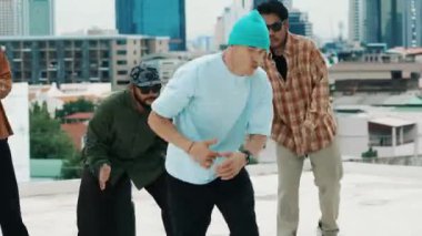 Çatıda çok kültürlü arkadaşlar varken profesyonel İspanyol break dansçısı B boy dansı. Genç modern dans grubu hip hop hareketi yapıyor. Tarz, moda, aksiyon. Açık hava sporu 2024 hiphop..
