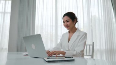 Çalışma masasında internet içeriği için dizüstü bilgisayar kullanan genç bir iş kadını ya da evden çalışan bir sekreter. Canlılık