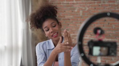 Kadın nüfuzlu kişi, sosyal medya veya blog için canlı yayın yapan video klip eleştirmeni Cilt Bakımı 'nı çekiyor. Kozmetik stüdyosu ışıklandırmalı mutlu genç kız çevrimiçi pazarlama oturumu yayını için..