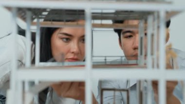 Ev modeli yapısını ölçmek için birlikte çalışan kooperatif mühendisi kapatın. Genç ve güzel mimar ev modelini ölçerken erkek mühendis performansını destekliyor. Tertemiz..