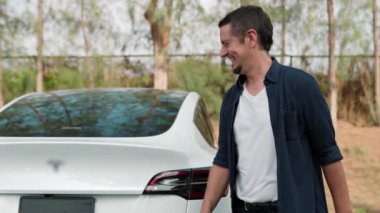 Çiftler, sonbahar sezonu boyunca milli parka yaptıkları yolculuk sırasında EV arabalarını dinlenme tesisinde elektrik bataryasıyla şarj ediyorlar. Çevre dostu arabayla tatil yapmak. Yükselt